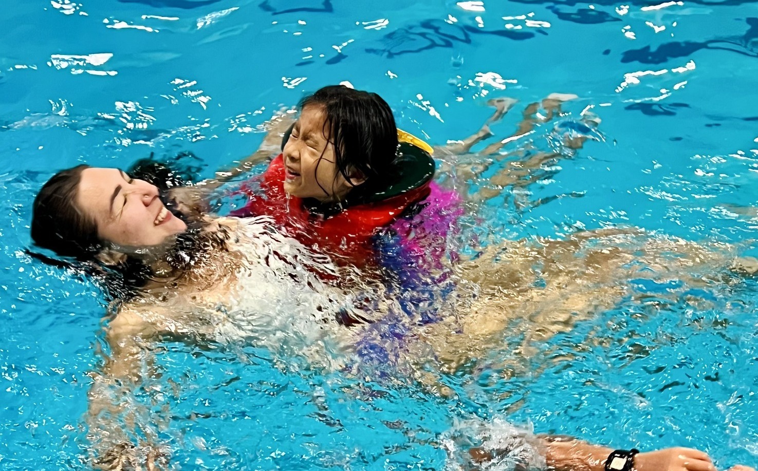 Adult and a kid having fun at the pool