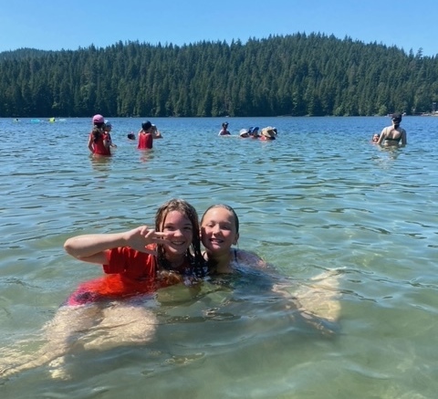 two smiling kids in the water at the beach