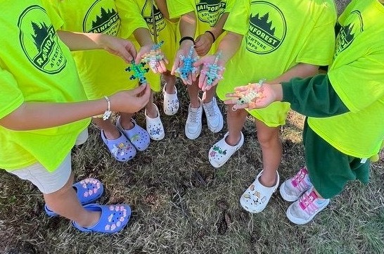 two campers holding sticks in the forest